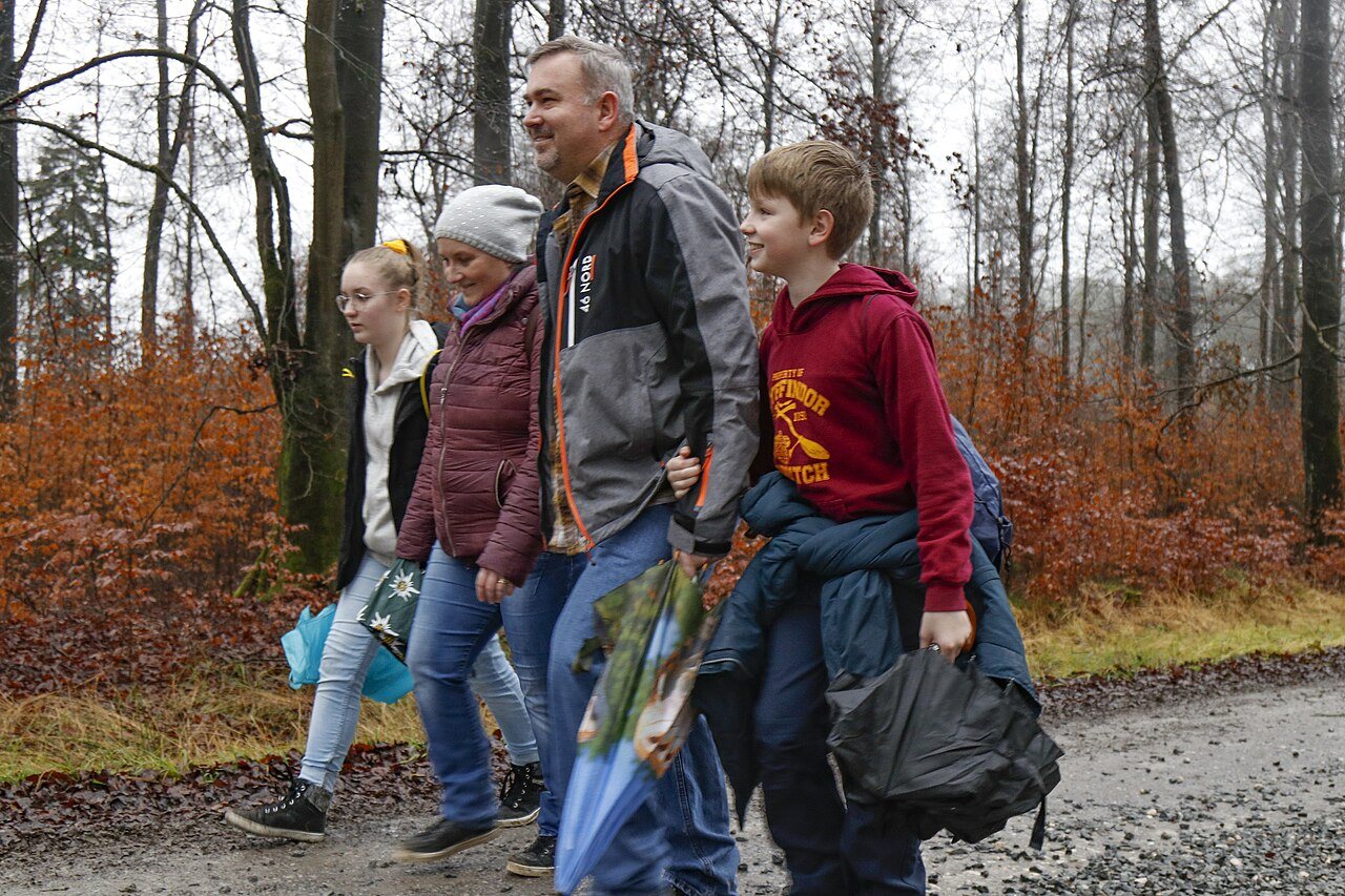 A family walking in woodland, shown as a family-walk illustration.