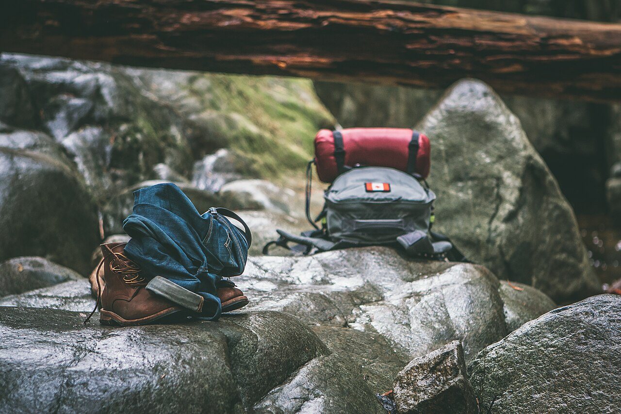 Walking gear beside a stream, shown as a packing illustration.